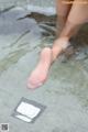 A woman's feet in the water with a pad on it.