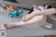 A woman laying on top of a kitchen counter next to a bowl of fruit.