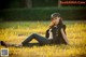 A woman sitting in a field of tall grass.