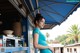 A woman standing in front of a blue awning.