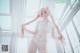 A woman in a white lingerie posing for a picture.