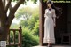 A woman in a white dress standing on a porch.