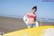 A woman in a bikini standing next to a yellow surfboard.