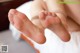 A close up of a woman's bare feet on a bed.